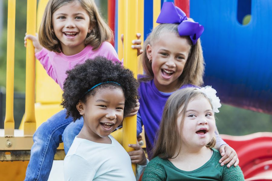 Four smiling children on a playground